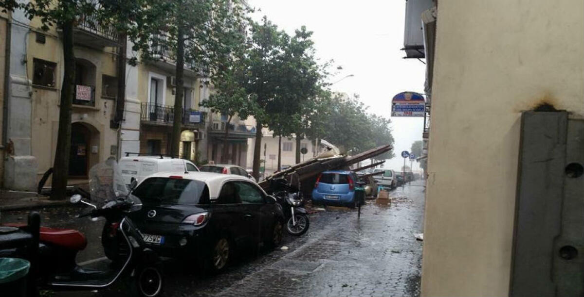 Fortissimo vento sulla città, un'impalcatura si abbatte su due auto in sosta: paura nel centro storico - 