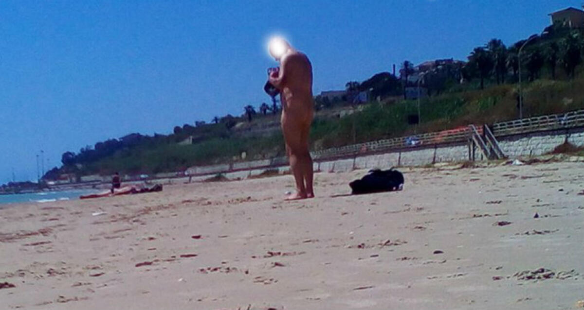 In spiaggia completamente nudo, sul lungomare un tuffo senza veli - L'uomo ha abbandonato i vestiti per un tuffo in mare