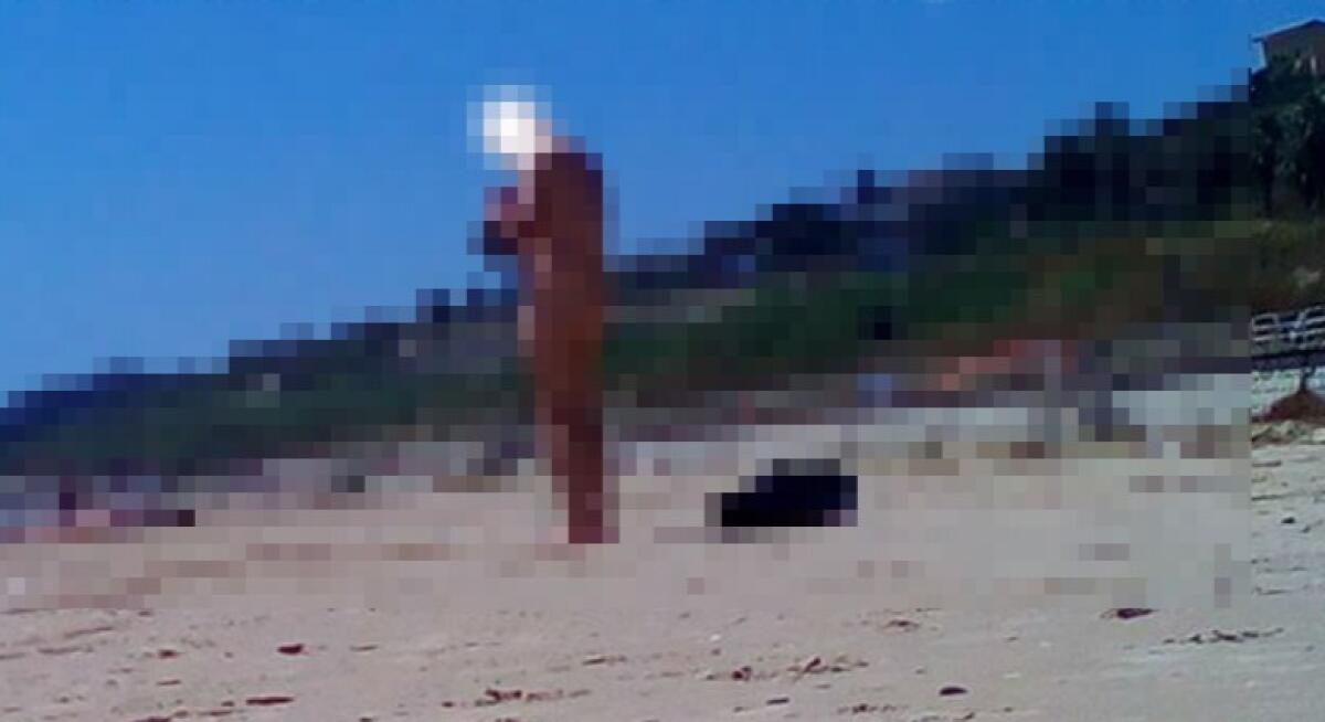 Lungomare, un uomo completamente nudo in spiaggia -